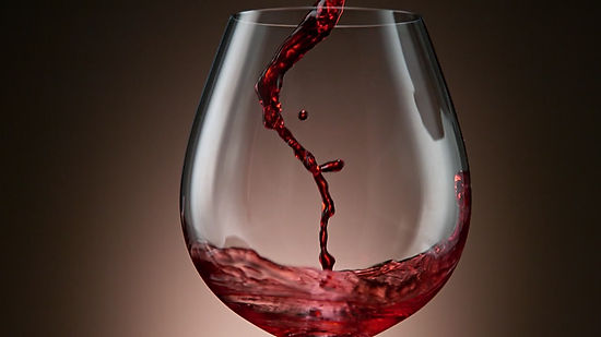 Camera follows red wine pouring into glass
